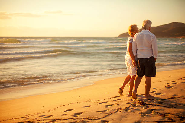 istock Senior couple walking on the beach 174811104