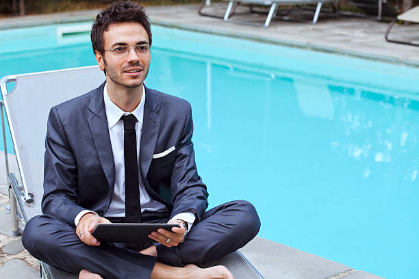 istock Businessman Working with Tablet Closed to a Swimming Pool 174811297