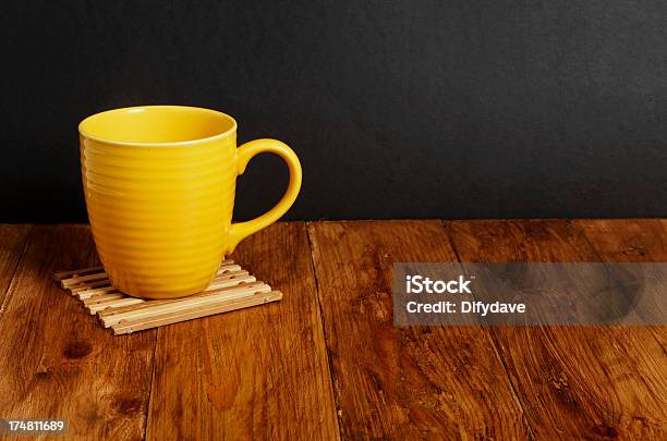 Amarillo Taza En La Superficie De Madera Con Fondo Oscuro Foto de stock y más banco de imágenes de Alfarería