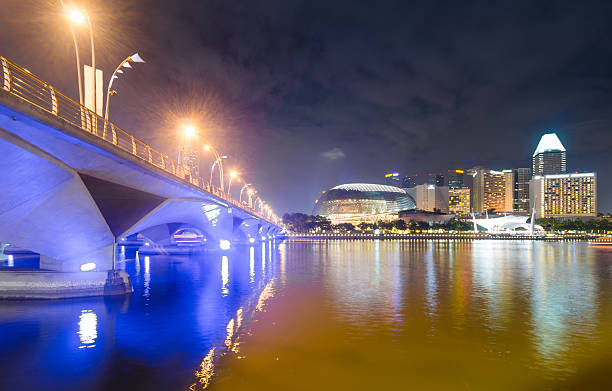 singapore skyline al atardecer de al otro lado de la bahía. - merlion singapore marina bay lighting equipment fotografías e imágenes de stock