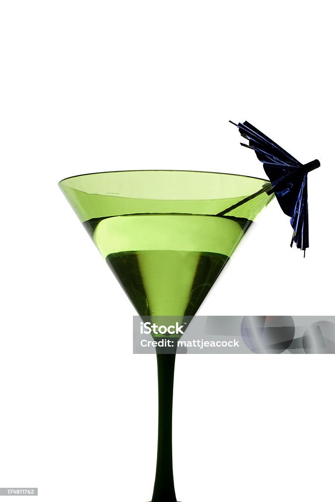 A cocktail with an umbrella in a green tinted glass. Cocktail with umbrella Alcohol - Drink Stock Photo