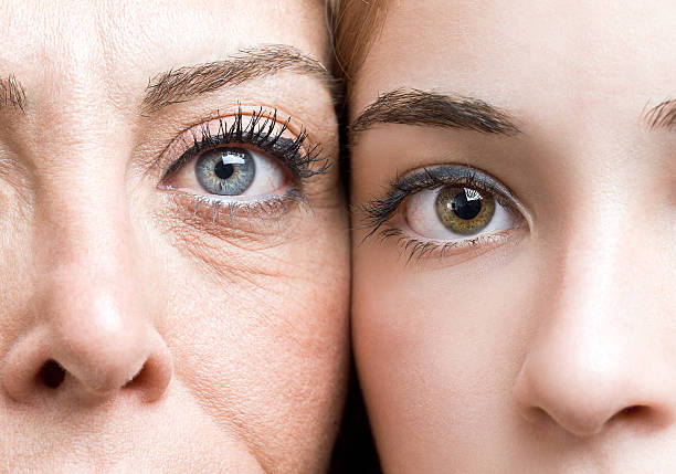 Mature mother and daughter "Mature mother and daughter, heads together, close-up portrait of their eyes" cheek to cheek photos stock pictures, royalty-free photos & images