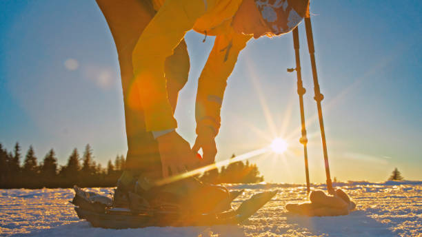 istock Woman skier adjusting ski boot on snow. Snowshoe walker. 1748122520