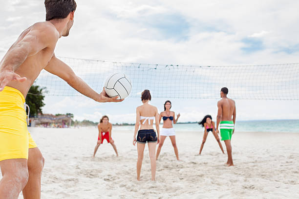 jovens amigos, jogar vôlei na praia - volleyball beach volleyball beach sport imagens e fotografias de stock