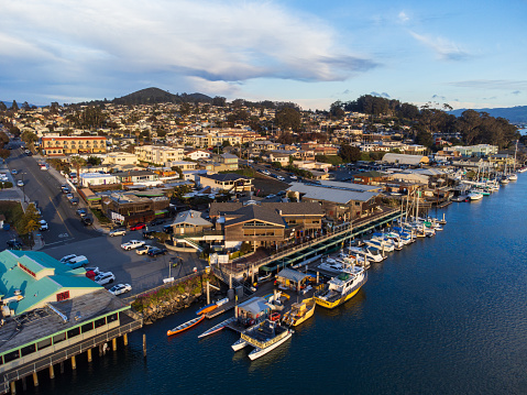An aerial view of the town of Morro Bay, California, taken from the bay, at sunset.