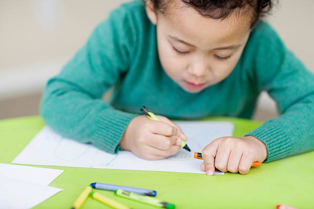 istock little boy colouring at daycare 174812416