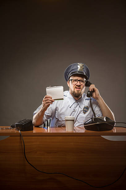 cop por teléfono con frustración expresión - desk police police station humor fotografías e imágenes de stock