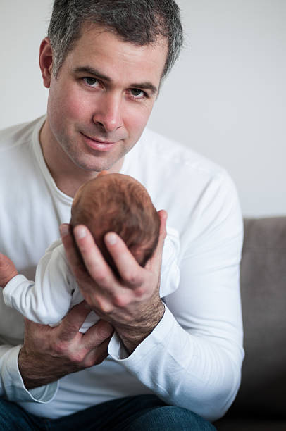 FATHER AND HIS NEWBORN stock photo