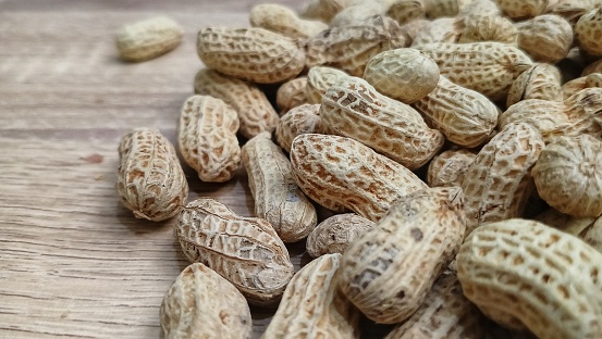 salted roasted peanuts, a healthy snack on wooden background. copy space.