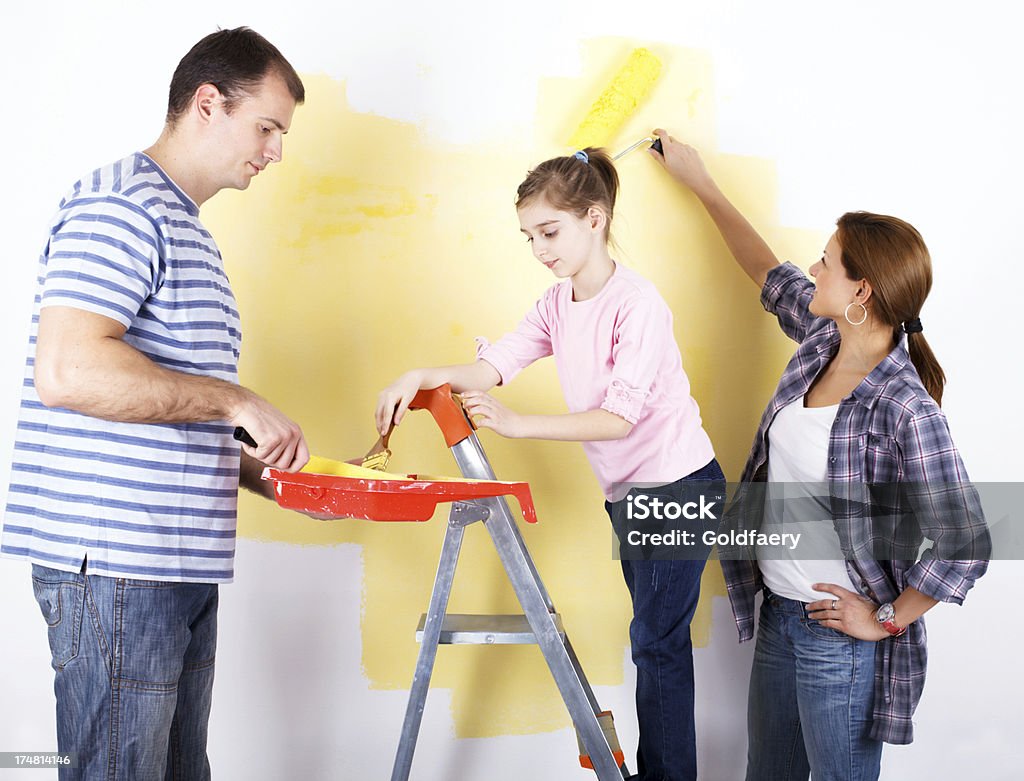 Famiglia di tre dipingere il muro - Foto stock royalty-free di Abbigliamento casual