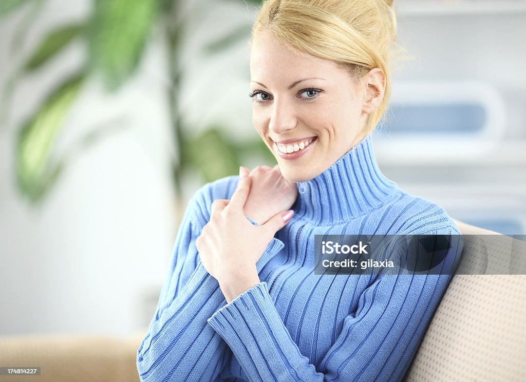 Mulher loira atraente sentada no sofá. - Foto de stock de 20-24 Anos royalty-free