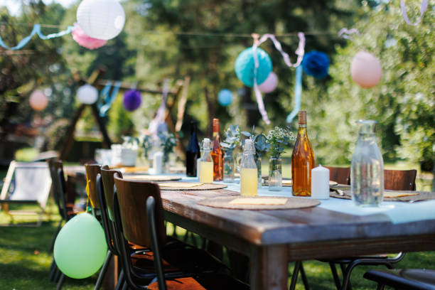 istock Set table for summer garden party. Table setting with glasses, fruit lemonade, fresh fruits and salads and delicate floral decoration. Colorful paper decorations for party. 1748142697
