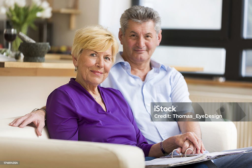 Senior couple assis sur un canapé - Photo de 65-69 ans libre de droits