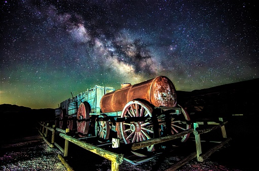 This is a historic 20 mule train wagon in Death Valley National Park. On warm spring moonless nights, the rising Milky Way and sky glow sparkle in the sky.