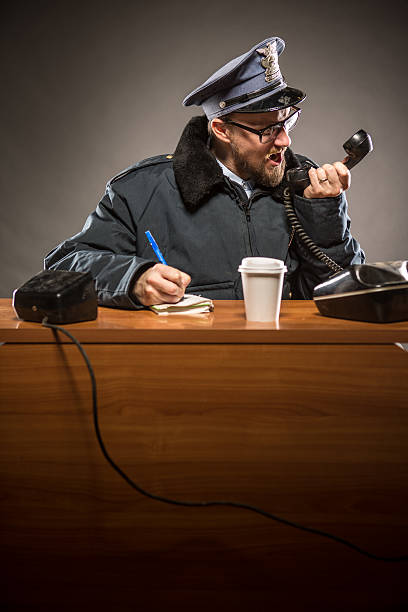 policeman yelling en el teléfono - desk police police station humor fotografías e imágenes de stock