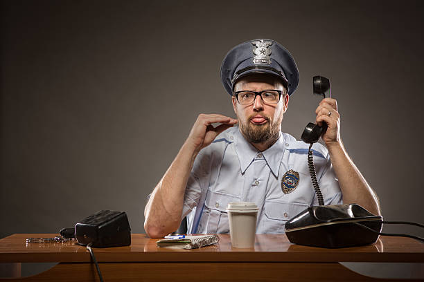 hablar con la mano: frustrado policía - desk police police station humor fotografías e imágenes de stock
