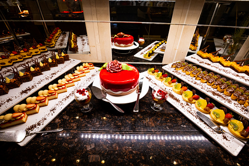 variety of sweets including cakes, eclairs and Turkish sweets, arranged beautifully on a table in a luxury all-inclusive hotel. perfect for use in food, travel and luxury related designs