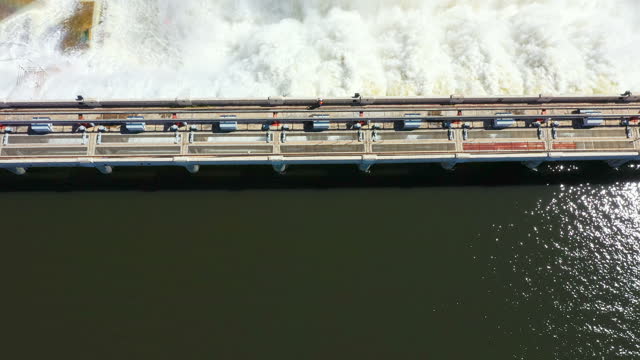 Water, nature and above of a dam in summer with a waterfall, power and energy supply. Drone view, landscape and a river in an environment for a commercial lake, travel or hydroelectric station