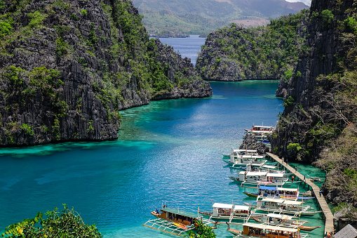 Many wooden boats docking on the Kayangan Lake in Coron Island, Philippines. Kayangan Lake is an isolated volcanic lake in the middle of Coron Island.
