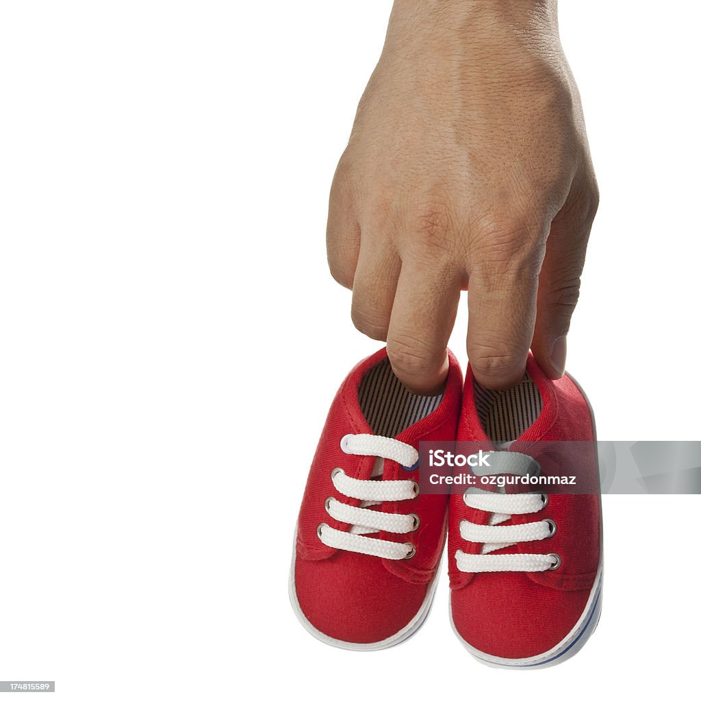 Hombre que agarra par de zapatos de bebé - Foto de stock de 30-39 años libre de derechos