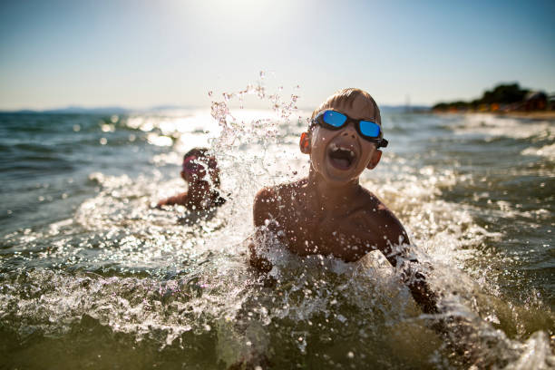 istock Happy children playing in waves on the sunny summer day 1748156579