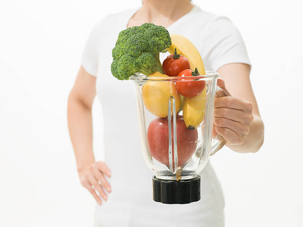 женщина держит фрукты и овощной сок extractor - healthy eating accessibility improvement electric juicer стоковые фото и изображения