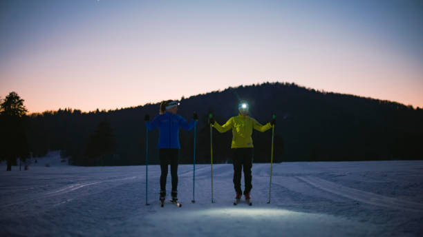 istock Two women skiing on snowy mountain slope during dusk 1748163242