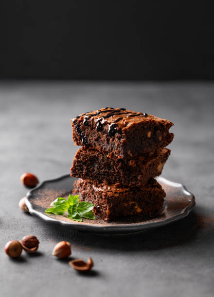 istock A stack of chocolate brownies with mint, hazelnuts and salted caramel on a dark  background with nuts. 1748165923