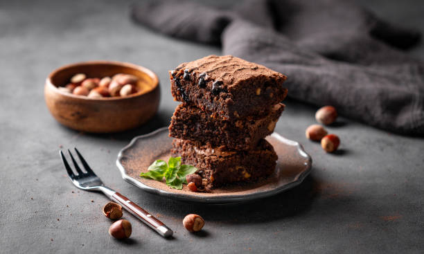 istock A stack of chocolate brownies with mint and  hazelnuts on a dark  background with nuts. 1748165946