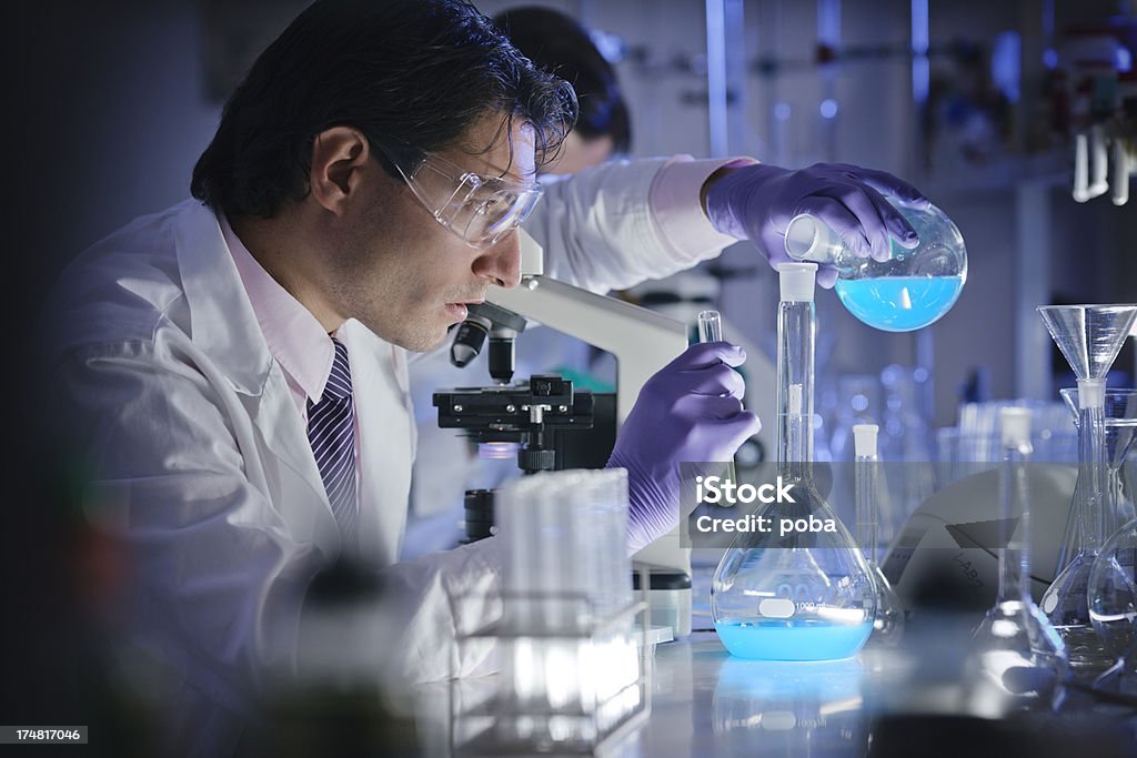 Gli scienziati che lavorano in laboratorio con microscopio e esaurito - Foto stock royalty-free di Accudire