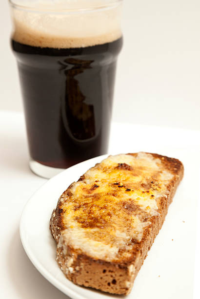 Welsh Rarebit and Stout A slice of Welsh rarebit (cheese on toast) with a glass of stout.  Shallow depth of field.See similar images in my Food & Drink Lightbox welsh culture stock pictures, royalty-free photos & images