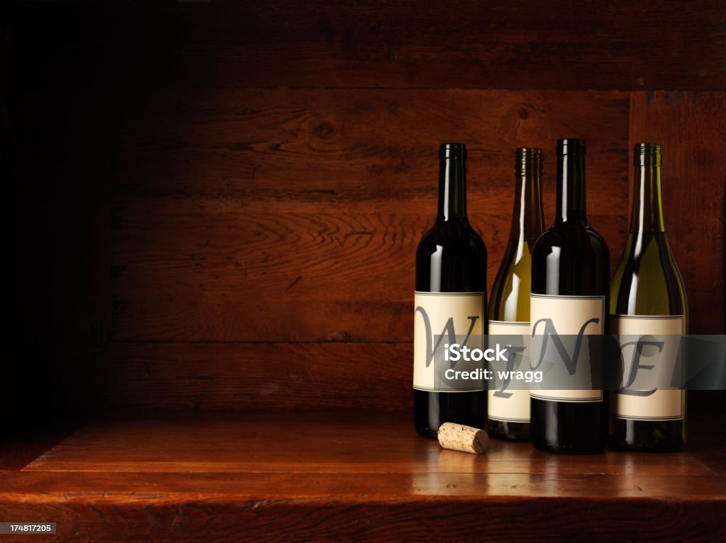 Vermelho e branco garrafas de vinho em uma mesa de madeira de carvalho - Foto de stock de Bebida alcoólica royalty-free