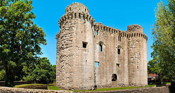 Nunney Castle, Frome, Somerset, UK "THIS CASTLE IS AN UNINHABITED RUIN. Situated near Frome in Somerset, Nunney Castle is a small, French style castle surrounded by a deep moat, built for Sir John Delamare in 1373. A veteran of the Hundred Years War, Sir John would later become Sheriff of Somerset. During the Civil Wars (1642-51) Cromwell's men used cannon to blast a great hole in the north wall of the castle, forcing the garrison to surrender. The badly damaged wall finally collapsed into the moat in 1910.Similar images:" keep fortified tower photos stock pictures, royalty-free photos & images