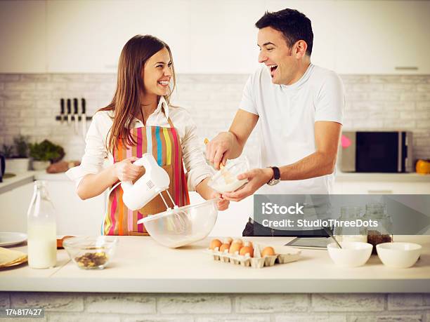 Felice Giovane Coppia In Cucina - Fotografie stock e altre immagini di Cuocere al forno - Cuocere al forno, Relazione di coppia, Abbigliamento casual