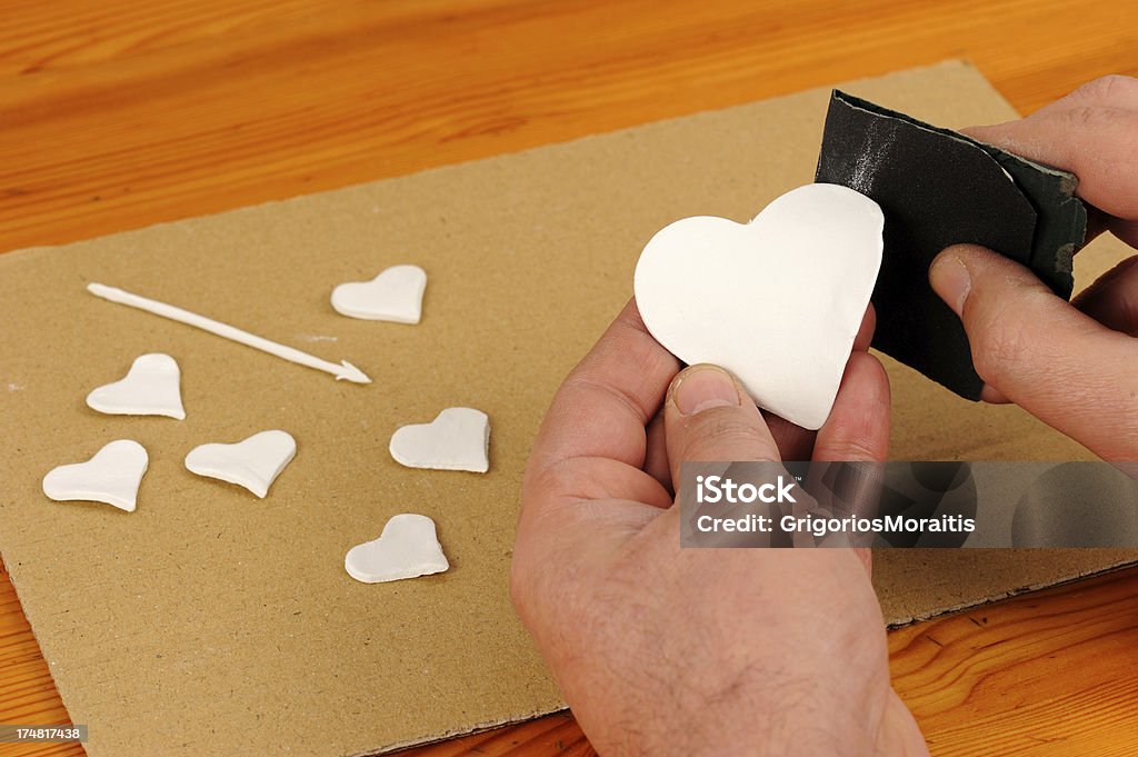 Ponçage un coeur en argile - Photo de En argile libre de droits