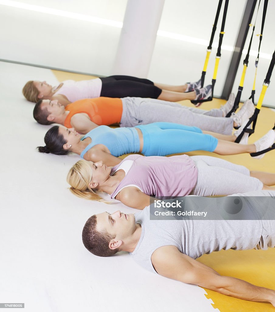 Suspension training Group of people performing TRX suspension training in gym. 30-39 Years Stock Photo