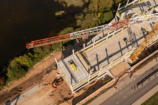 Drone photography of new office building construction site, cranes and construction workers during autumn sunny day
