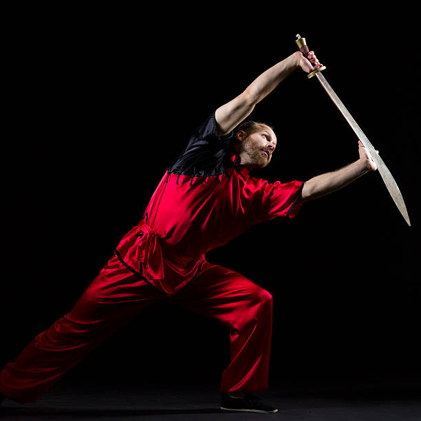 di kung fu shaolin posizione con dao spada su nero - self defense wushu action aggression foto e immagini stock