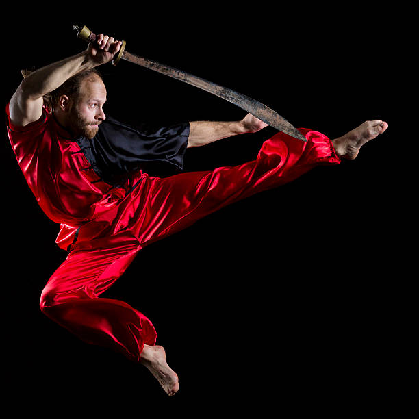 shaolin kung fu fighting position mit dao schwert in midair - wushu action aggression power stock-fotos und bilder