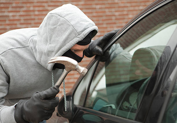 istock Burglar with crowbar trying to enter car, stealing valuables 174818690
