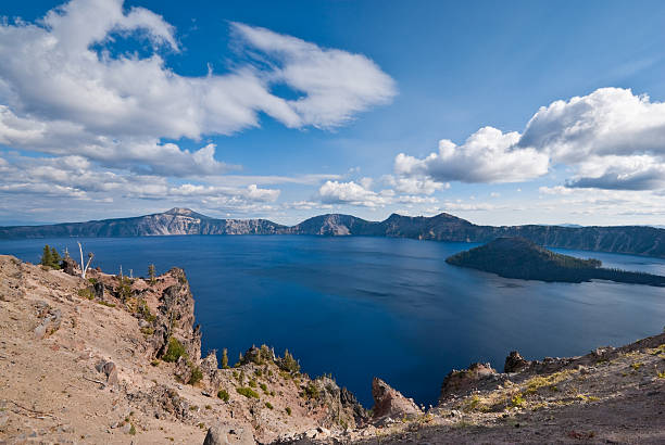 Crater Lake and Wizard Island Crater Lake exists in the blown-out caldera of a once mighty volcano known as Mount Mazama. This view of the lake and Wizard Island was taken from the West Rim Drive in Crater Lake National Park, Oregon, USA. jeff goulden crater lake national park stock pictures, royalty-free photos & images
