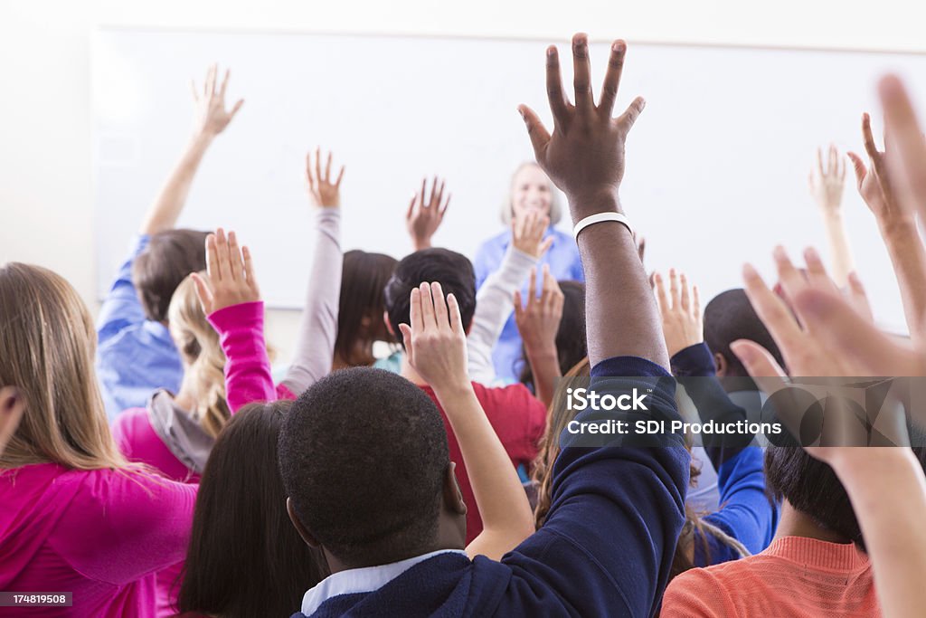 College students plantear manos para responder a la pregunta del profesor - Foto de stock de Alzar los brazos libre de derechos