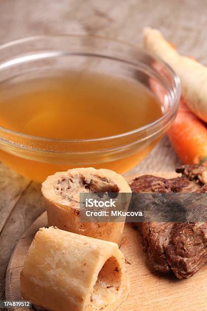 A Clear Bowl Of Beef Broth And Some Carrots Stock Photo - Download Image Now - Bone Marrow, Bouillon, Animal Bone