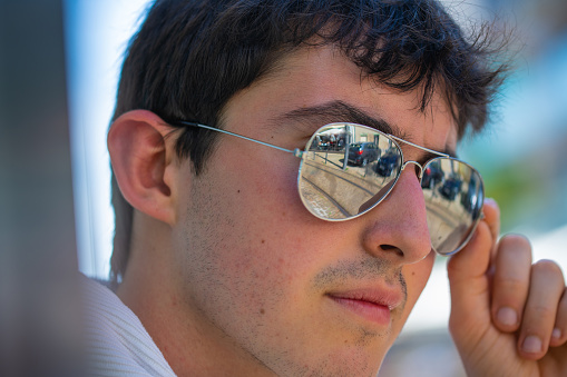 young man with sunglasses and white T-shirt and blurred background