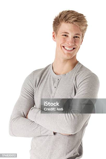 Sorridente Jovem De Pé Com Os Braços Cruzados - Fotografias de stock e mais imagens de Fundo Branco - Fundo Branco, Homens Jovens, Sweatshirt