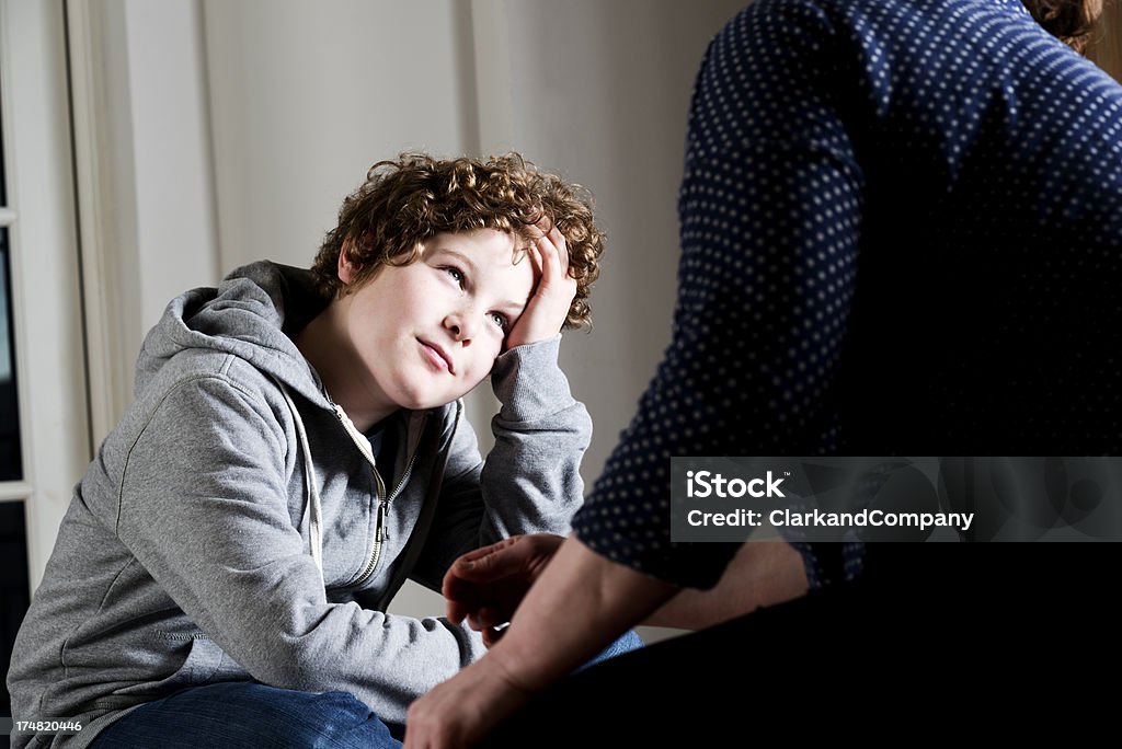 Candid Picture  of a Boy Talking To Parent or Teacher "Eleven year old boy talking to a parent,guardian or social worker." Child Stock Photo