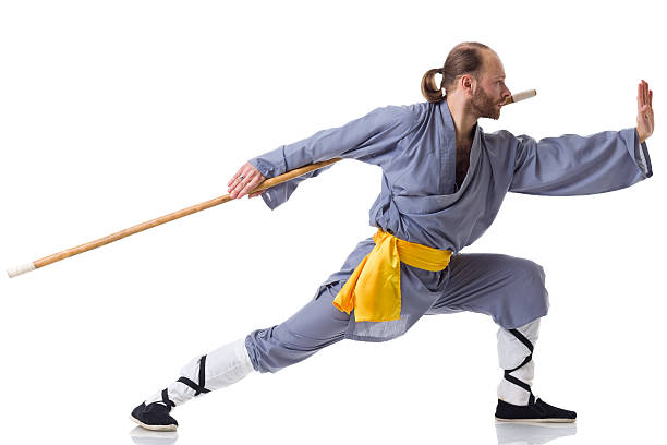 кунг-фу борьбе с позиции с деревянными stick изолирован на белом - wushu skill action aggression стоковые фото и изображения