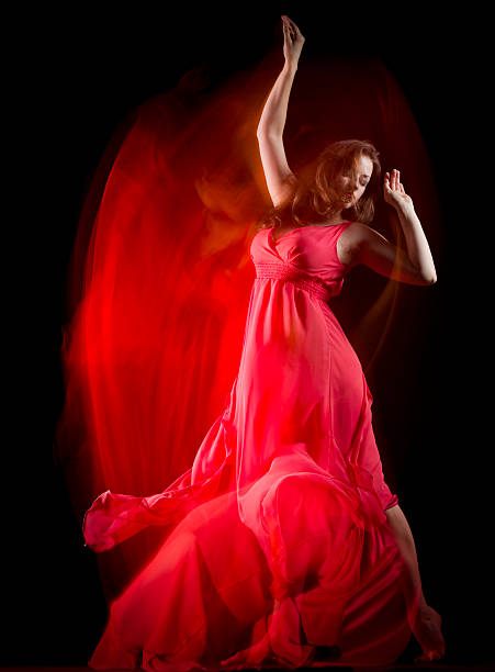 bailarina mujer en vestido rojo sobre negro de crear patrones - fantasy women blurred motion studio shot fotografías e imágenes de stock