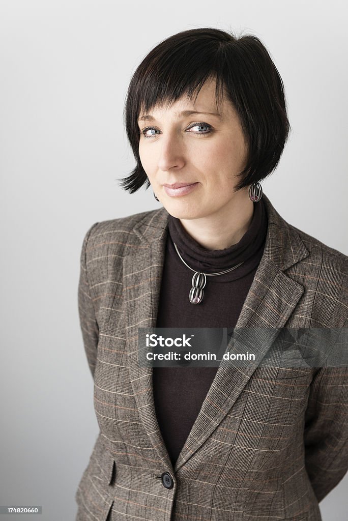 Mid adult woman in brown checkered jacket gently smiling Mid adult woman in brown checkered jacket gently smiling. 30-34 Years Stock Photo