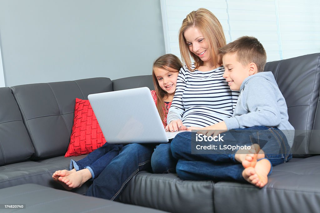 Salle de séjour-famille avec ordinateur portable tenue - Photo de Adulte libre de droits
